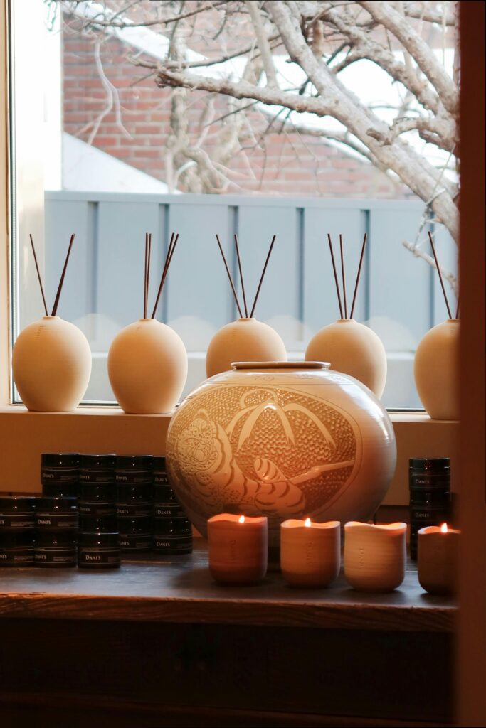 Bedroom diffuser candles décor with soft glowing lights, ceramic vases, and warm cozy ambience