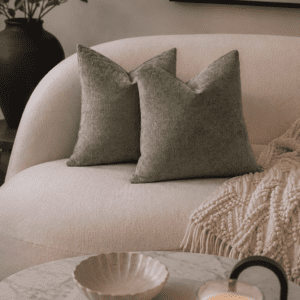 Sage green velvet decorative pillow covers on a cream sofa.