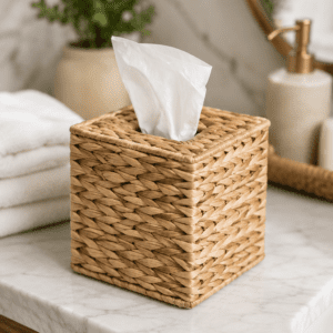 Handwoven rattan tissue box cover with white tissues on a marble bathroom countertop, adding natural warmth and modern farmhouse style to home decor.