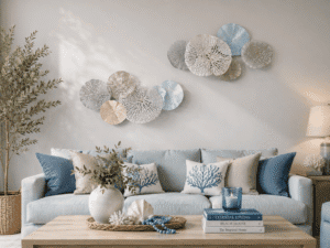 Coastal metal wall art set featuring layered coral-inspired discs in soft blue, white, and beige tones displayed above a modern coastal sofa.