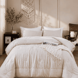 Soft white comforter set styled in a cozy neutral bedroom with layered bedding, macrame wall decor, natural textures, and warm morning sunlight.