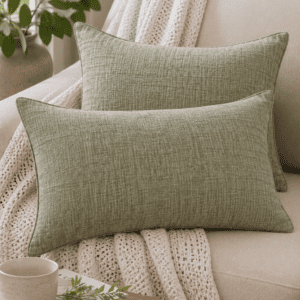Sage green linen throw pillow covers styled on a neutral sofa with a chunky knit blanket and cozy organic home decor.