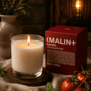Luxury heirloom tomato scented candle in a clear glass jar with elegant gift box, styled with fresh tomatoes and herbs in a cozy modern home.