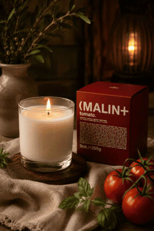 Luxury heirloom tomato scented candle in a clear glass jar with elegant gift box, styled with fresh tomatoes and herbs in a cozy modern home.