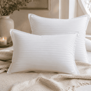 Luxury white striped pillow protectors on a cozy bed with a cream knit throw, candlelight, and neutral bedroom décor in a modern organic home.