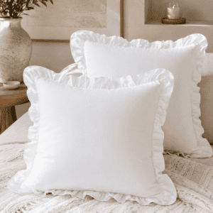 White ruffle throw pillow covers styled on a cozy neutral sofa with a chunky knit blanket, candle, and modern farmhouse living room décor.
