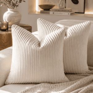 Ivory ribbed velvet throw pillow covers styled on a neutral sofa with a knitted throw blanket, candle, olive branches, and modern organic living room décor.