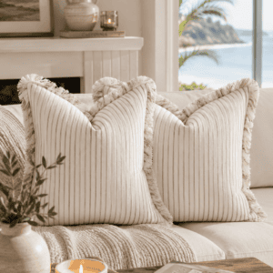 Cream ribbed fringe throw pillow covers styled on a neutral sofa with woven textures, candles, wood accents, and coastal decor in a bright modern farmhouse living room.