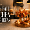 Cozy fall kitchen decor ideas featuring a warm neutral kitchen with a marble island, black pendant lights, a wicker tray centerpiece, orange florals, mini pumpkins, and glowing candles.