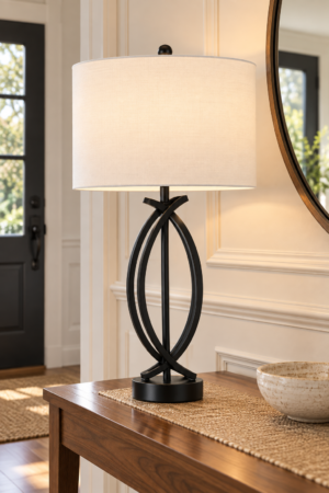 Modern black metal table lamp with sculptural loop frame and white fabric shade styled on an elegant wooden entryway console table.